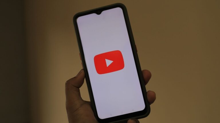 Close-up of a smartphone displaying the YouTube app logo on the screen.