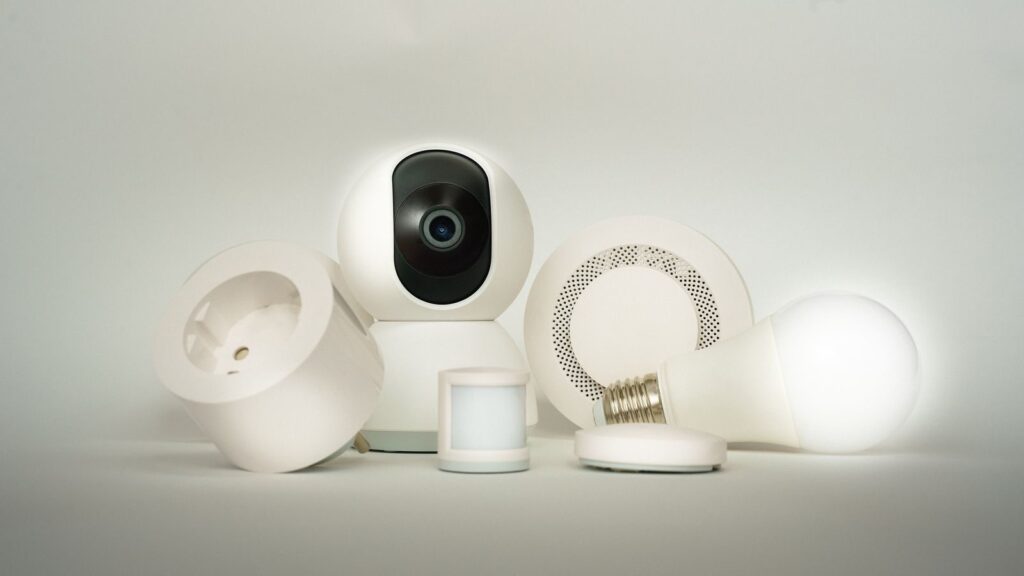 A collection of smart home devices, including a camera, light bulb, and sensors, on display.