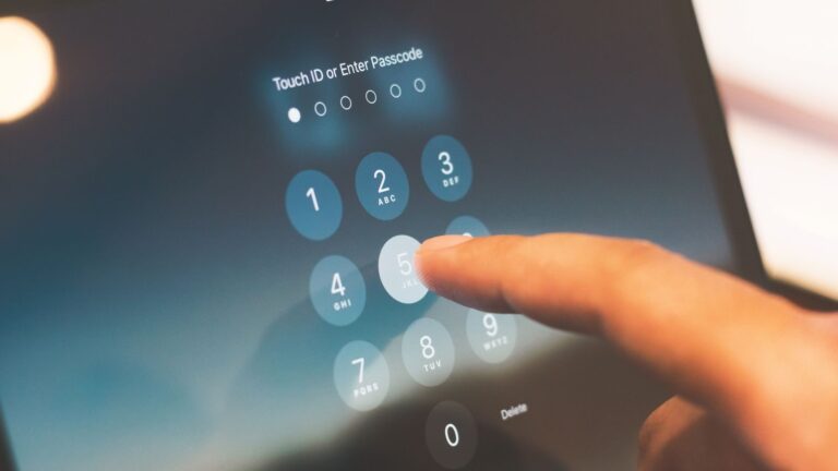 Close-up of a finger entering a passcode on a smartphone security screen.