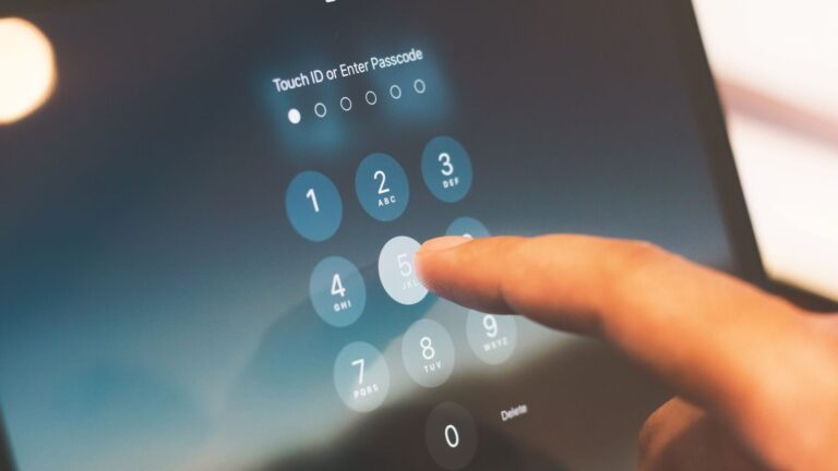 Close-up of a finger entering a passcode on a smartphone security screen.