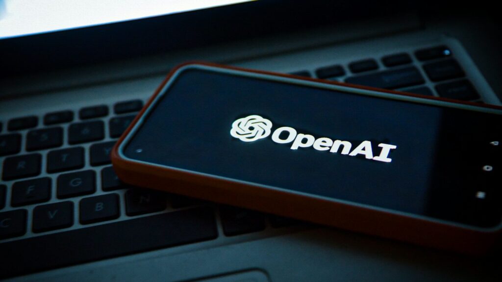 a cell phone sitting on top of a laptop computer
