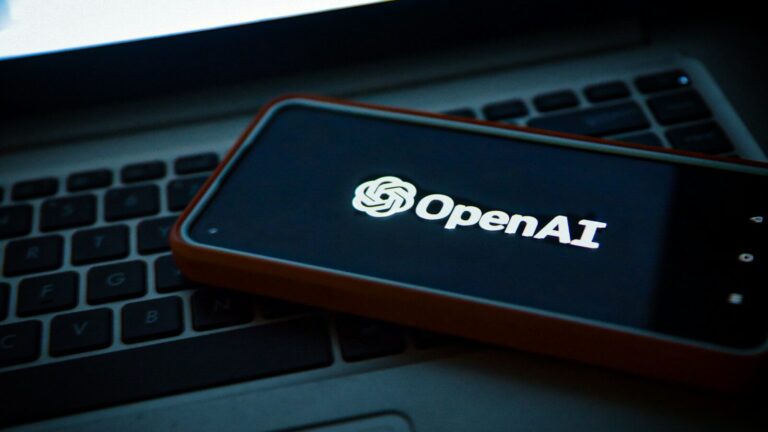 a cell phone sitting on top of a laptop computer
