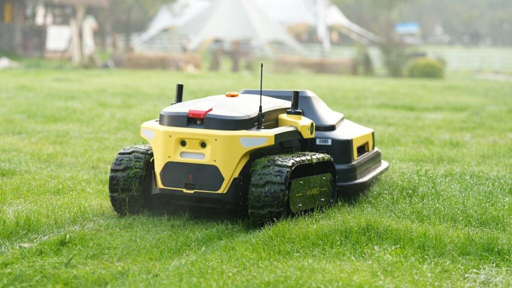 Robot lawnmower cuts grass in a backyard.