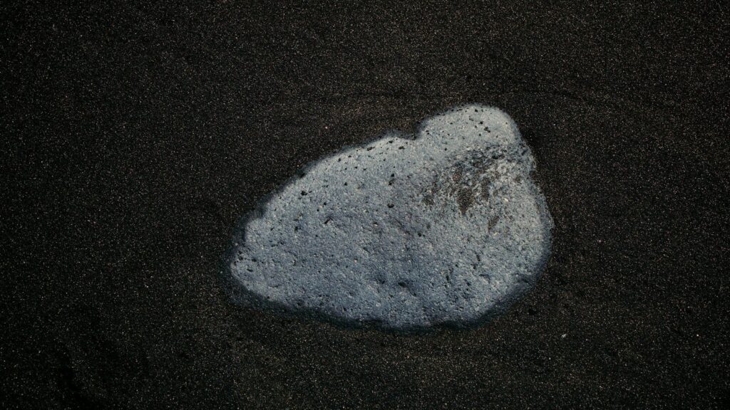 A foamy substance on dark sand