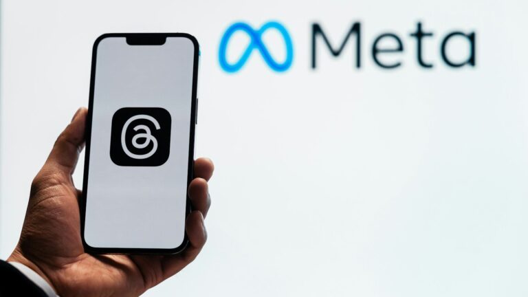 a person holding up a cell phone in front of a sign