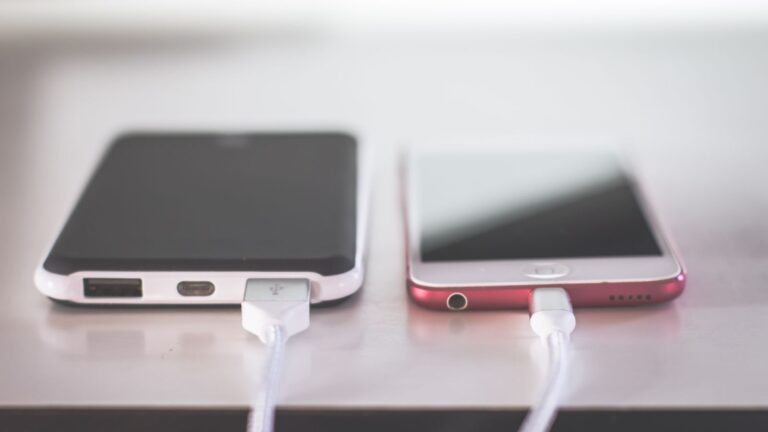 Two smartphones charging side by side on a desk. Modern and technological setting.