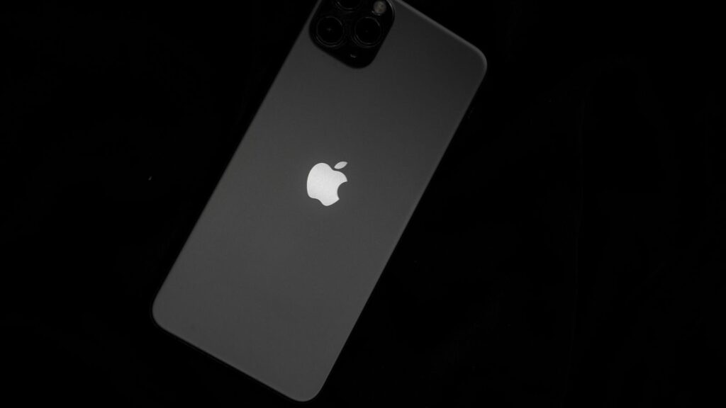 Close-up of a sleek smartphone featuring the iconic Apple logo against a black background.