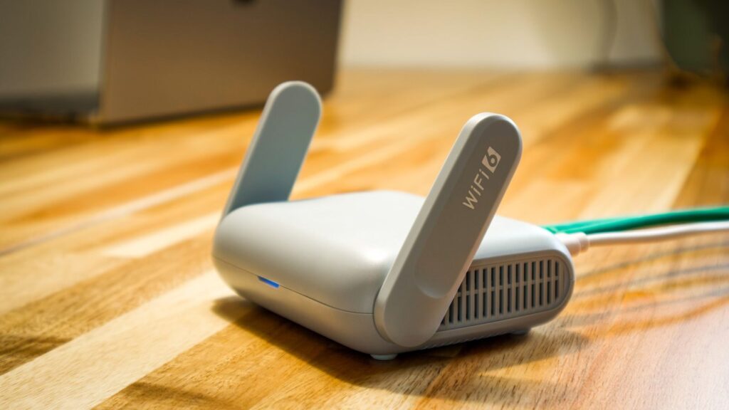 A sleek WiFi 6 router with antennas and cable on a wooden desk, perfect for modern home networks.