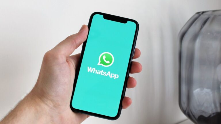 Close-up of a hand holding a smartphone displaying the WhatsApp app screen.