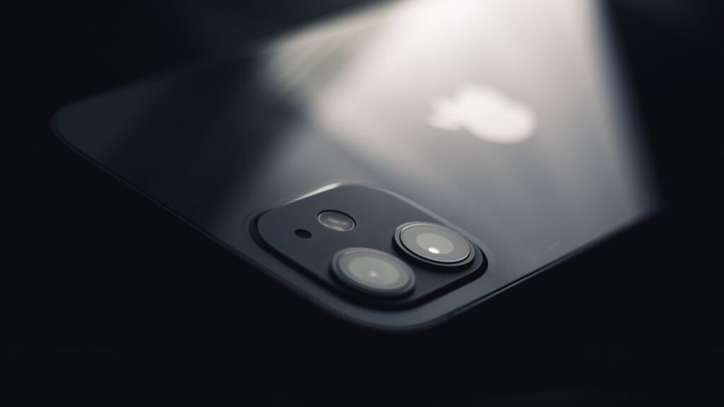 Close-up shot of a smartphone camera lens reflecting light, highlighting modern technology.