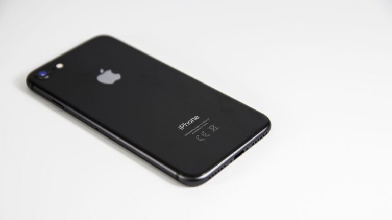 Black smartphone placed on a clean white surface, highlighting modern design and tech elegance.