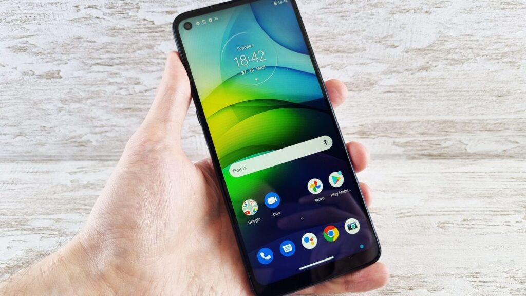 Close-up of a hand holding a smartphone with vibrant screen indoors, bright and clear display.