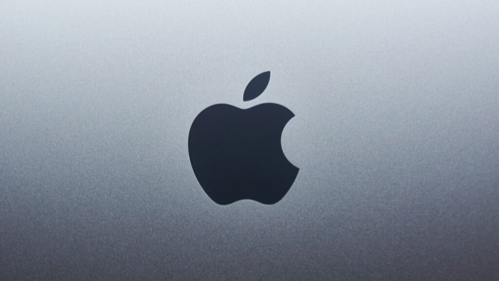 A dark apple logo centered on a smooth grey metallic surface