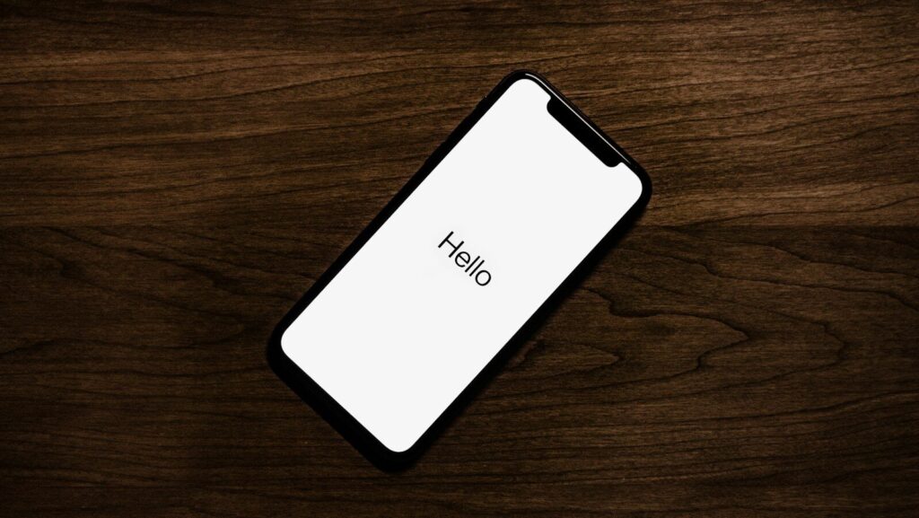 turned on iPhone on top of brown wooden surface