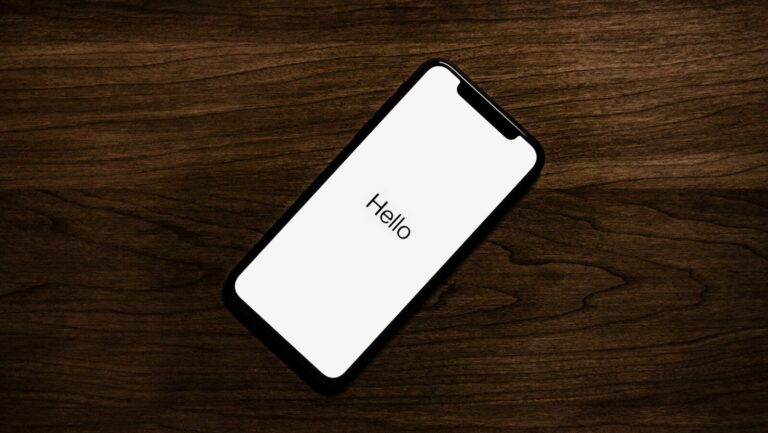 turned on iPhone on top of brown wooden surface