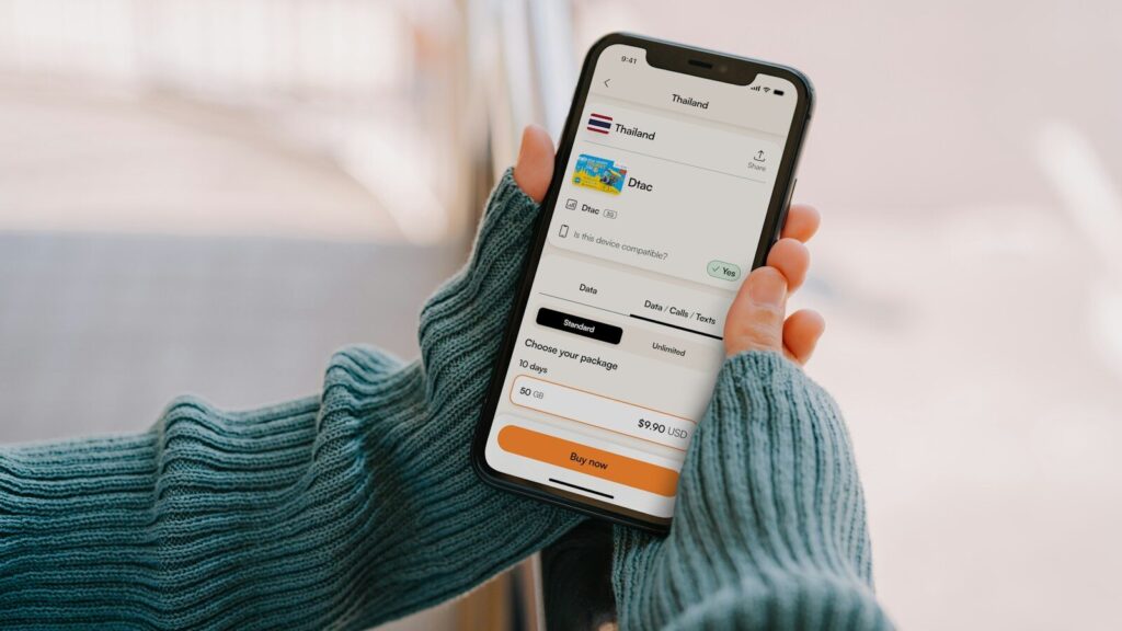 Person holding a smartphone with a travel app