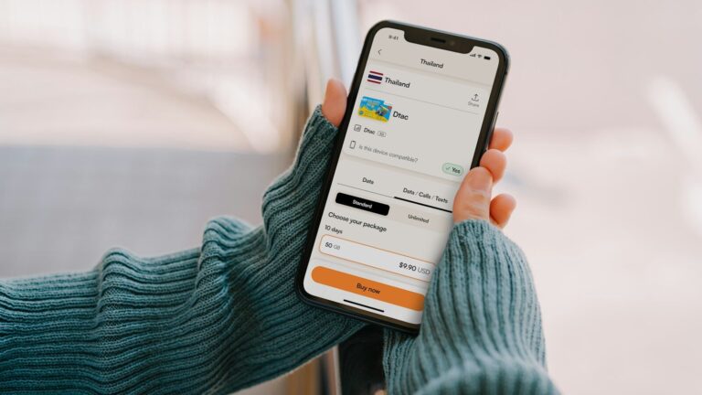 Person holding a smartphone with a travel app