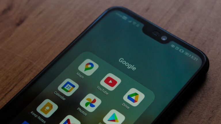 Close-up of a smartphone showing various Google apps on its screen.