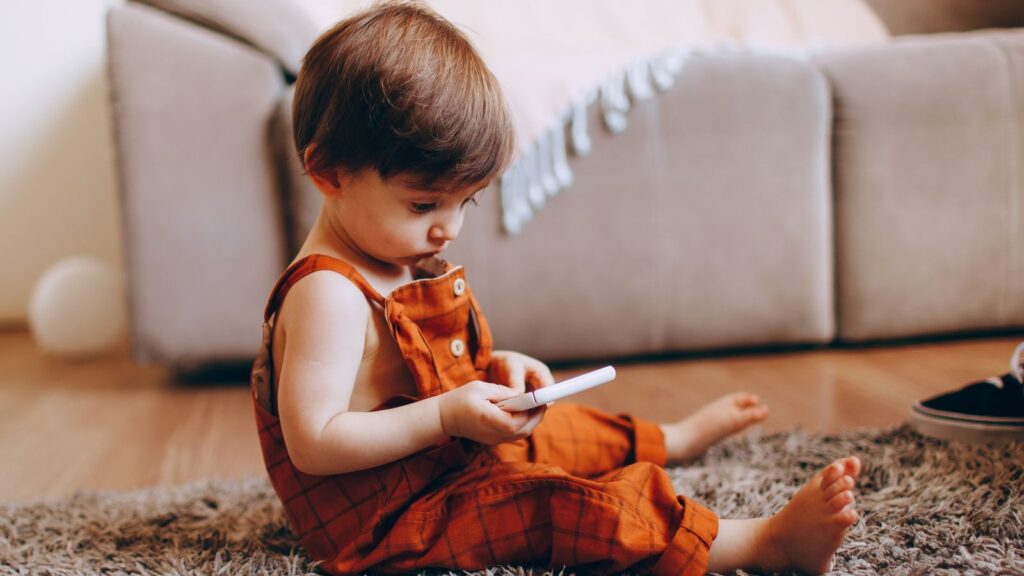 Cute toddler playing with a toy on a soft carpet in a cozy living room.