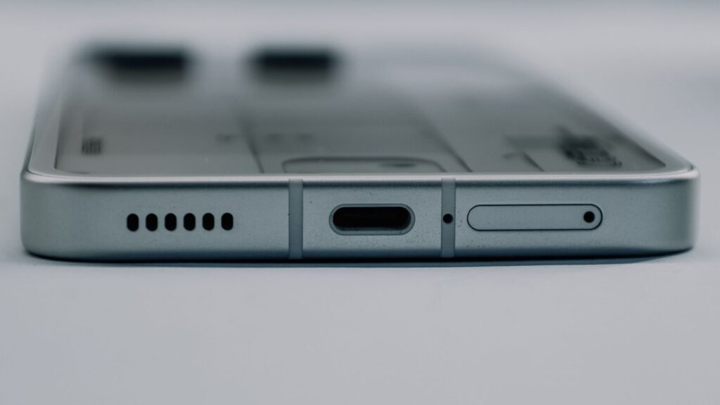 Detailed close-up of a smartphone's USB-C charging port and speaker grille, showcasing modern technology design.