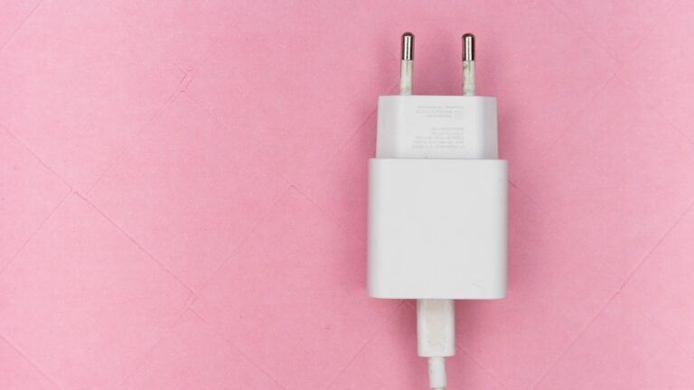 Minimalist white USB charger on a pink background, perfect for tech-themed projects.