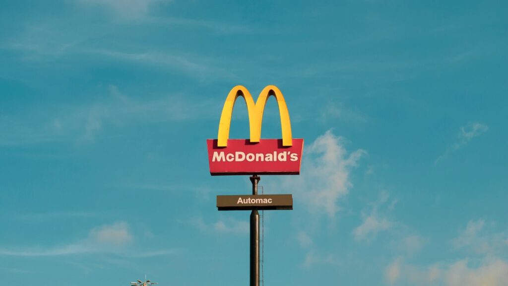 Bright McDonald's sign under clear sky, featuring the 'Automac' label.