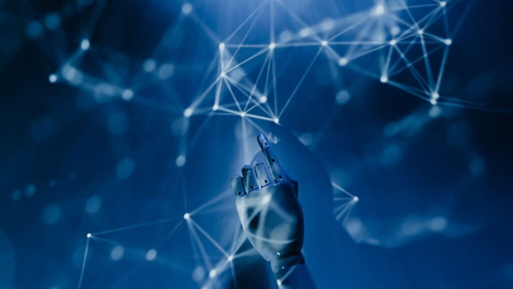 A robotic hand reaching into a digital network on a blue background, symbolizing AI technology.