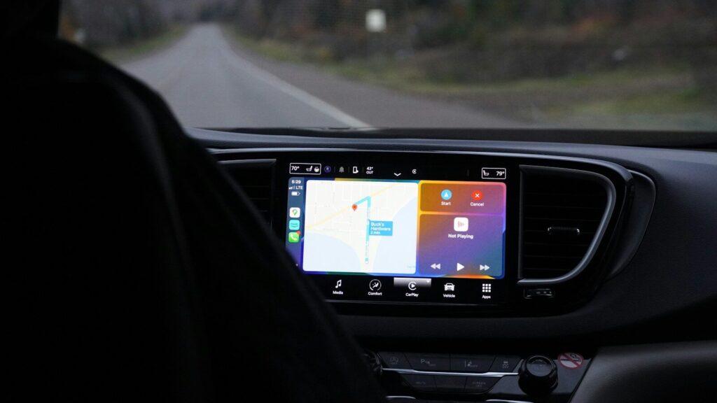 a man driving a car with a gps device in his hand