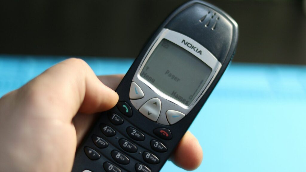 A hand holds a vintage nokia phone