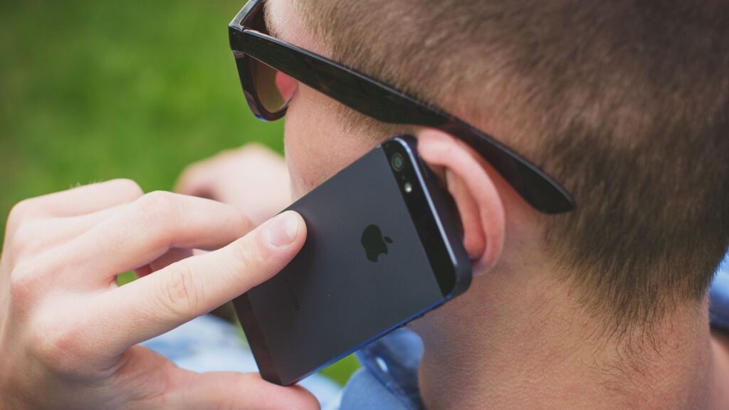 Man making a call outdoors using smartphone, focused on communication.