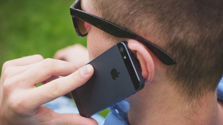 Man making a call outdoors using smartphone, focused on communication.