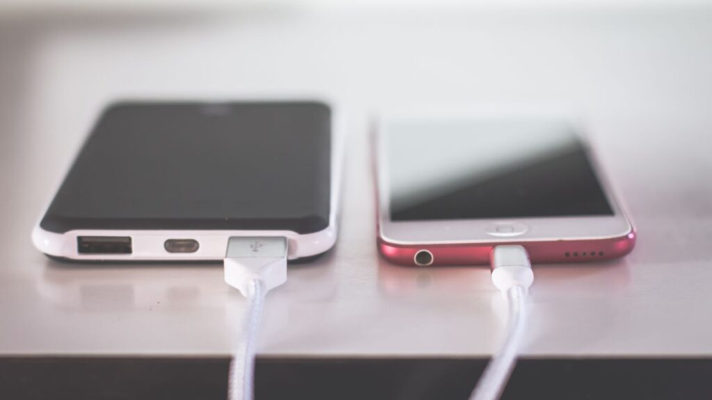Two smartphones charging side by side on a desk. Modern and technological setting.