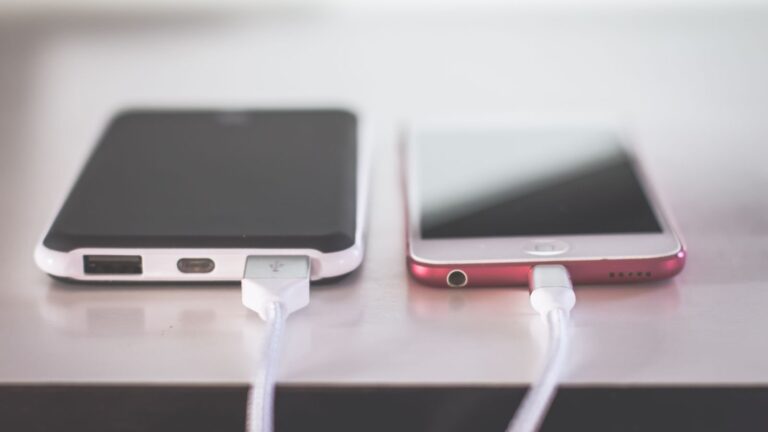Two smartphones charging side by side on a desk. Modern and technological setting.