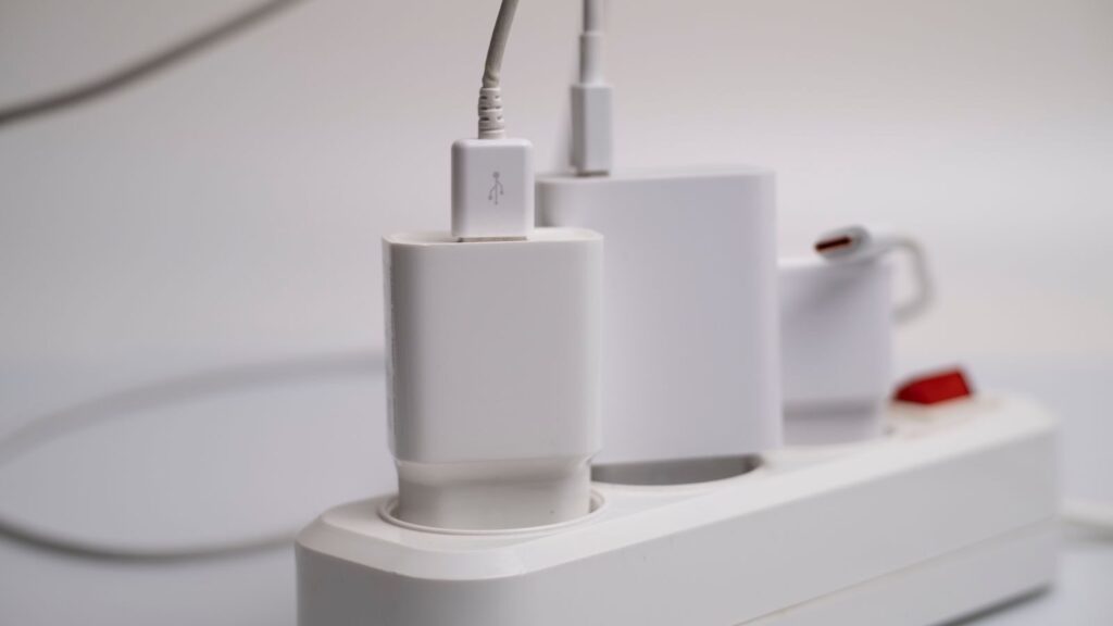 Minimalist composition of electronic device chargers connected to a power strip indoors.