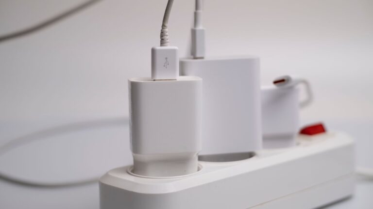 Minimalist composition of electronic device chargers connected to a power strip indoors.