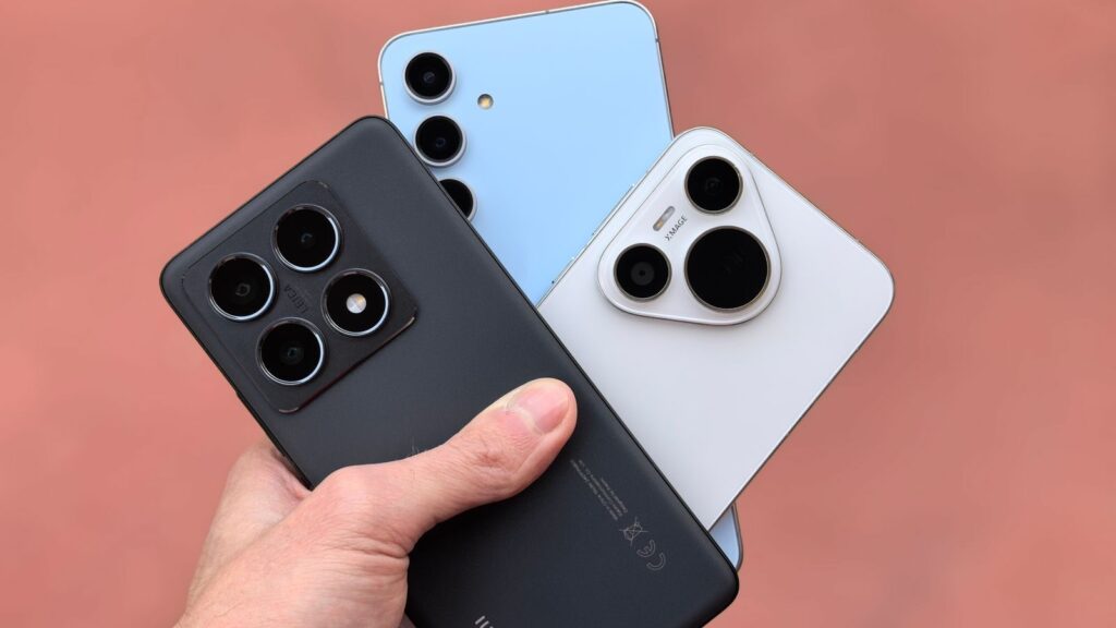 Close-up of a hand holding three modern smartphones with cameras in view, showcasing contemporary design.