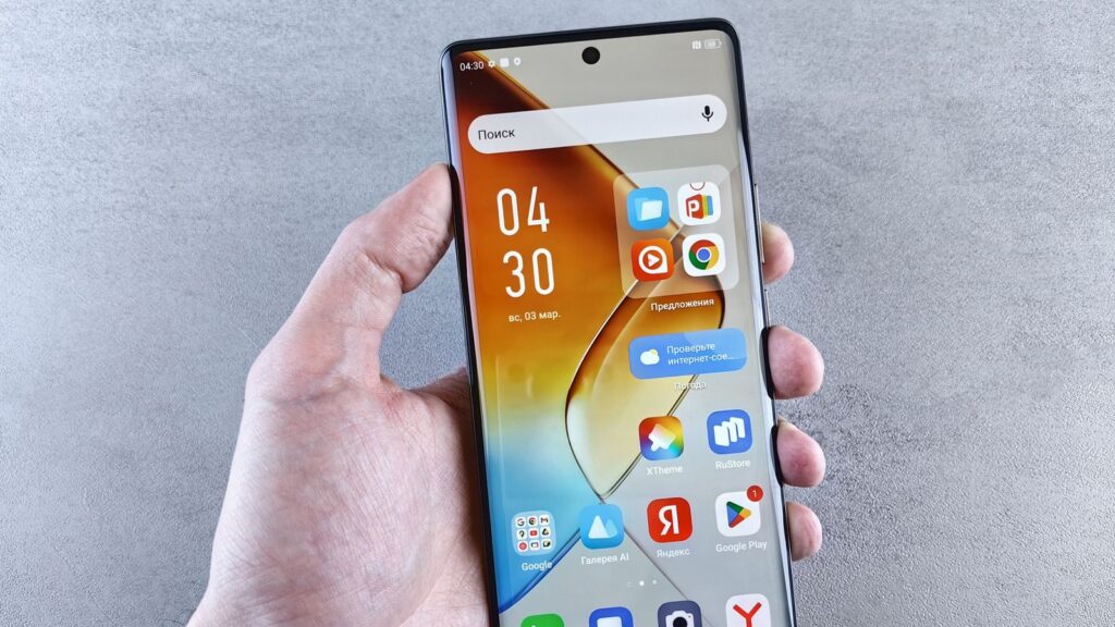 Close-up of a hand holding a smartphone displaying apps on the screen against a textured background.