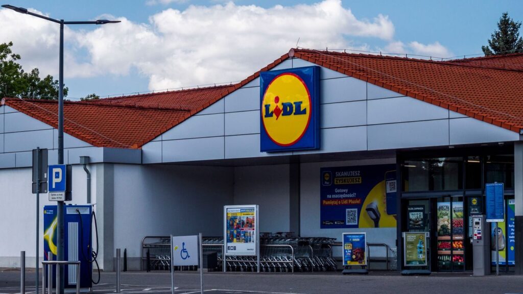 Lidl supermarket exterior featuring parking area and shopping carts on a sunny day.