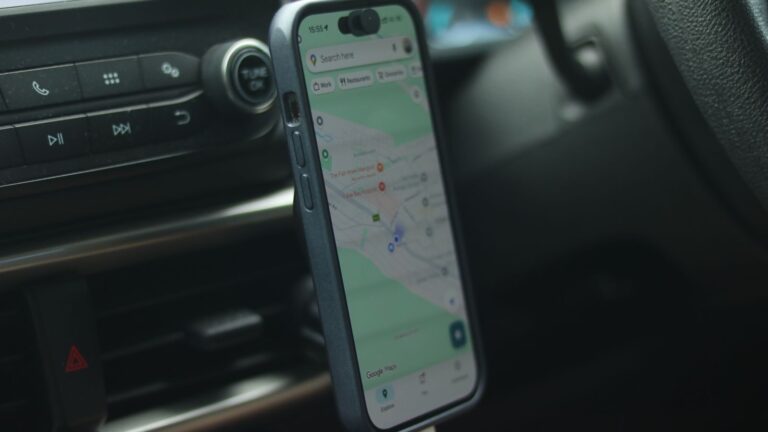 A smartphone with a map app displayed inside a car, showing modern navigation.