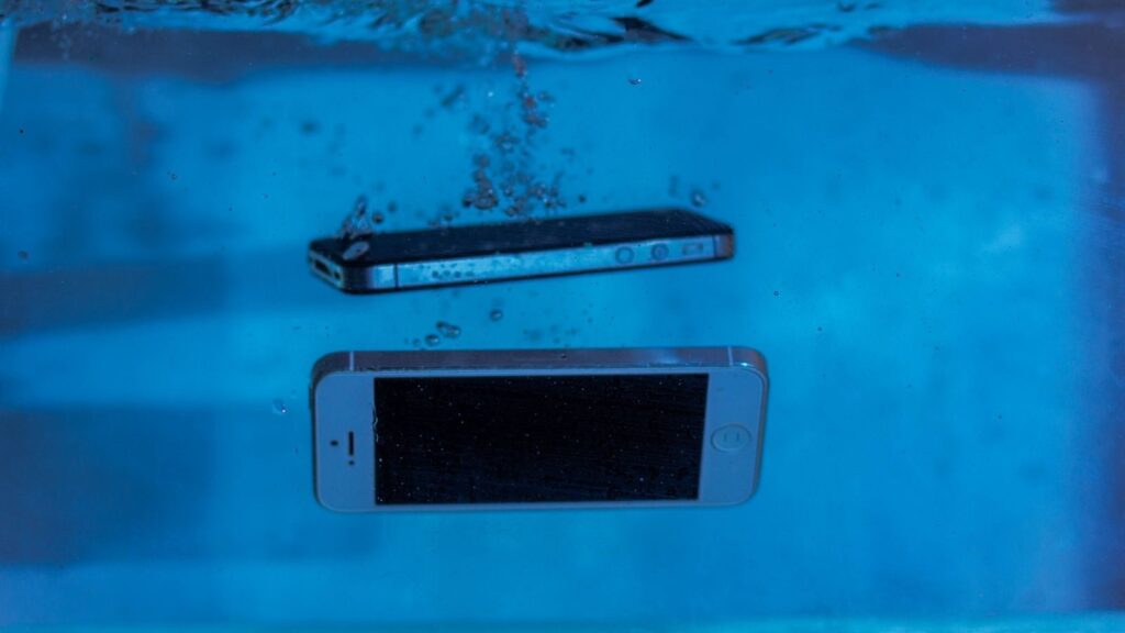 Two smartphones immersed underwater with bubbles, showcasing water-resistant test perspectives.