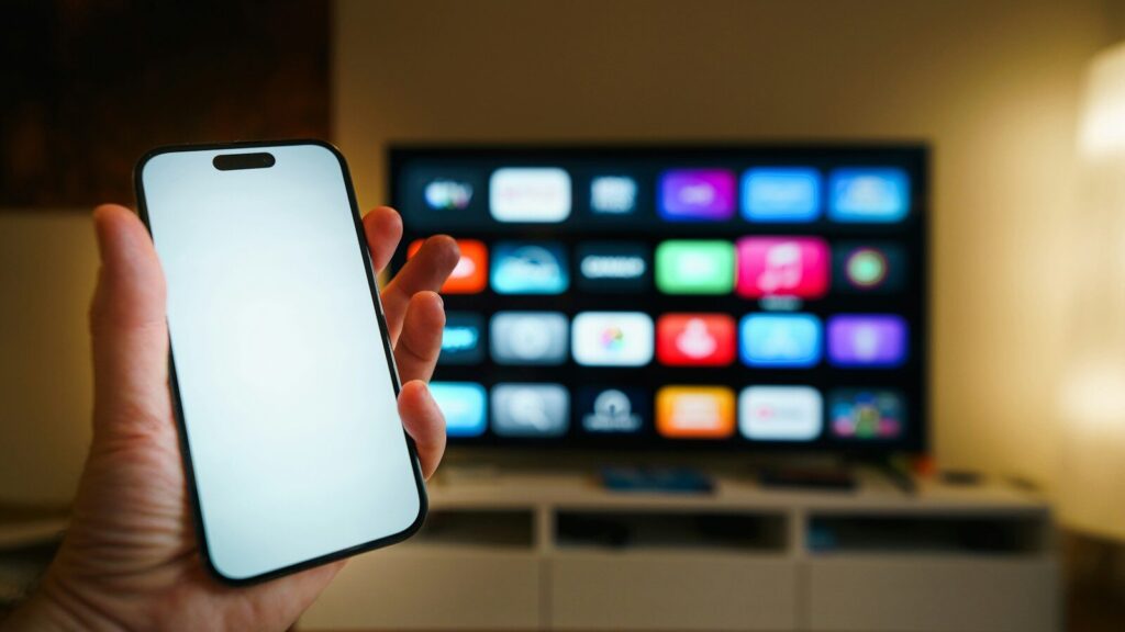Smartphone held in front of a smart TV screen