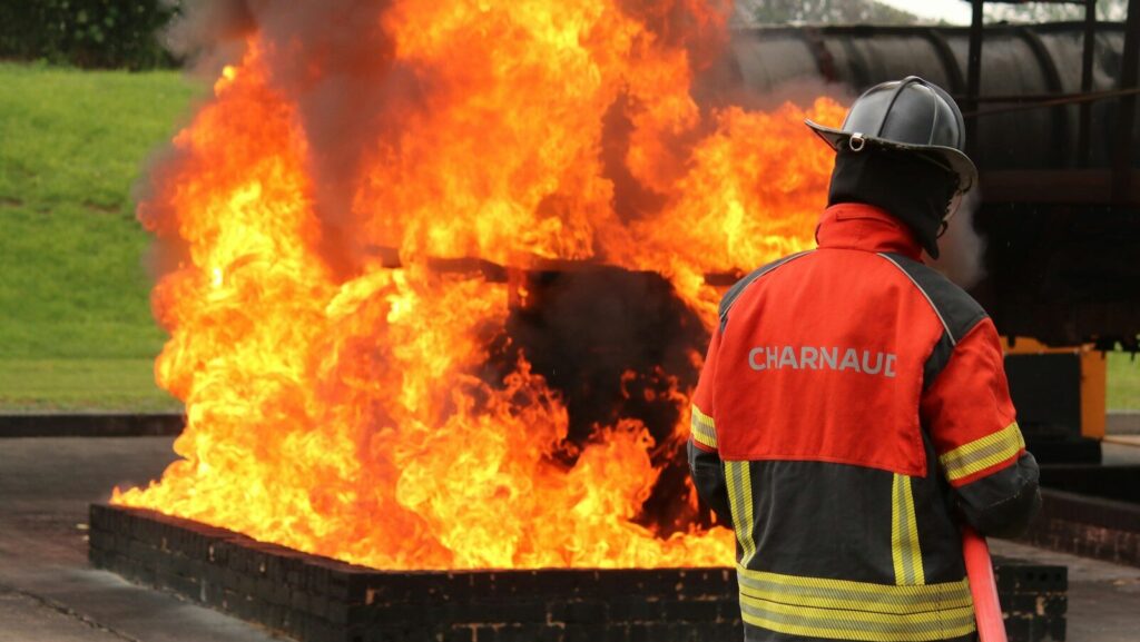 A firefighter faces a blazing fire
