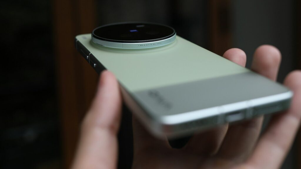 Hand holding a modern smartphone with large camera lens